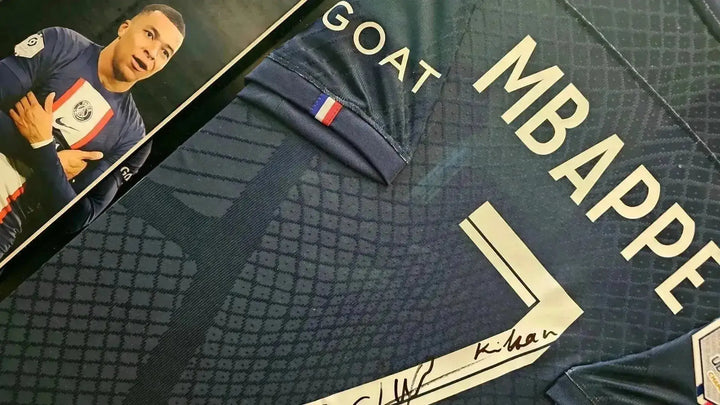 Detail of signed soccer jersey featuring player name Mbappé and squad number 7.