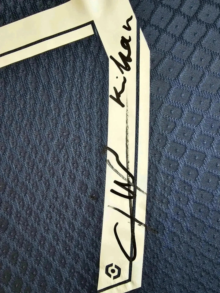 Signature of Kylian on navy blue detail of the signed Paris Saint-Germain soccer jersey.