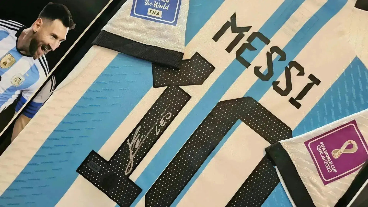 Detail view of signed Messi No. 10 soccer jersey with Argentina crest and FIFA World Cup tag.