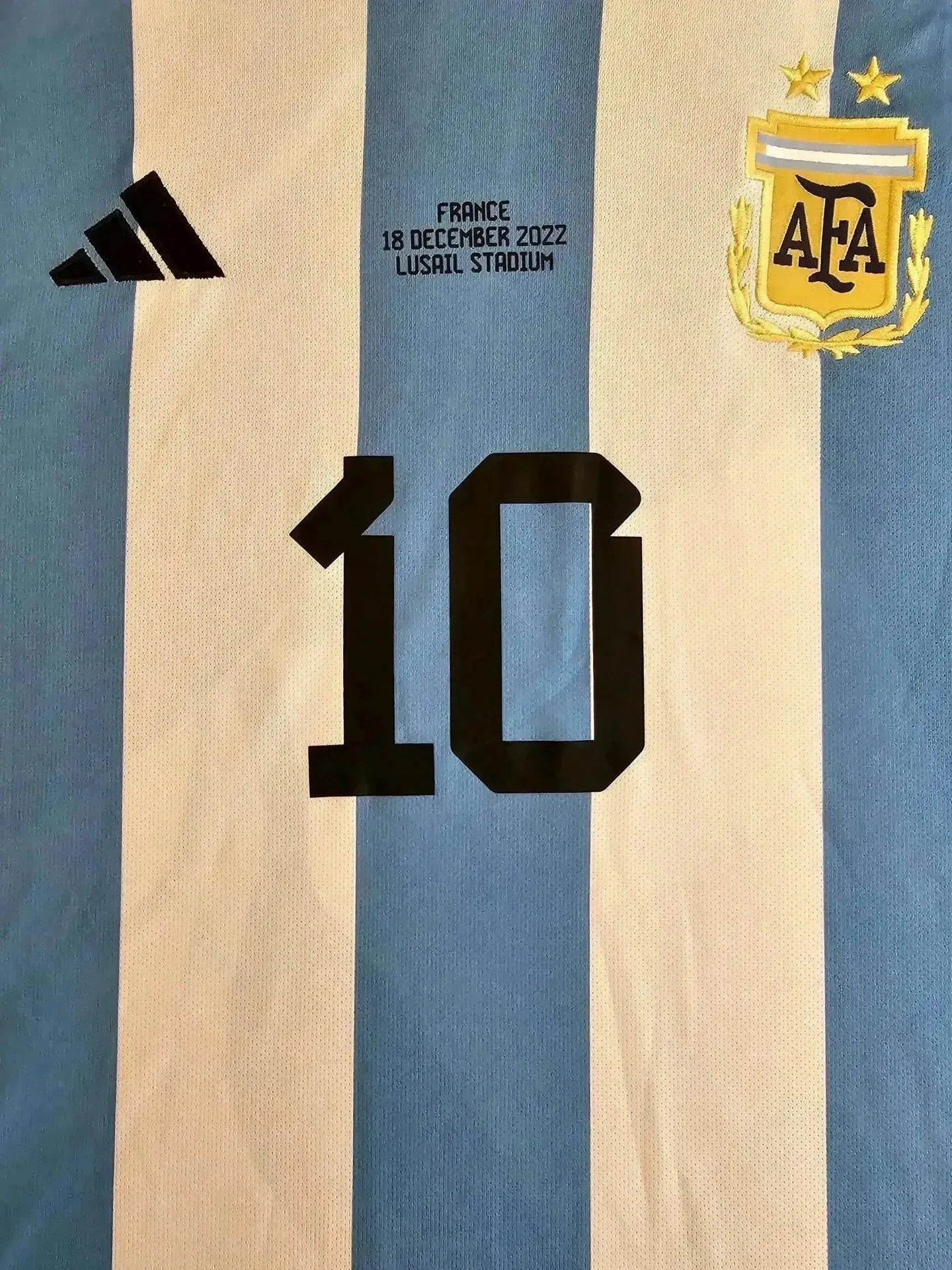 Detail view featuring No. 10, adidas logo, and Argentina crest with text from Lusail Stadium.