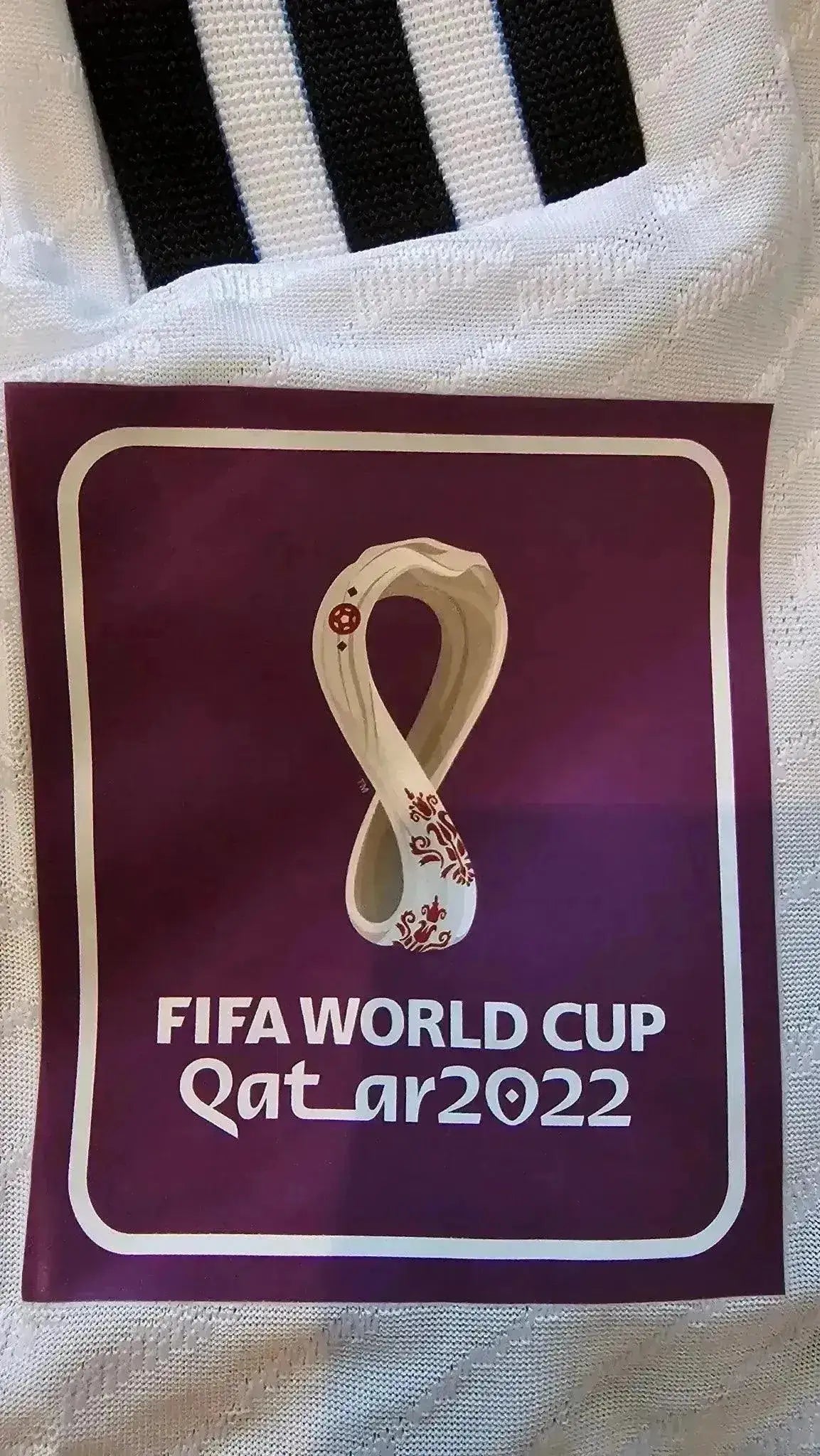 FIFA WORLD CUP Qatar 2022 tag featuring the infinity symbol and decorative elements.