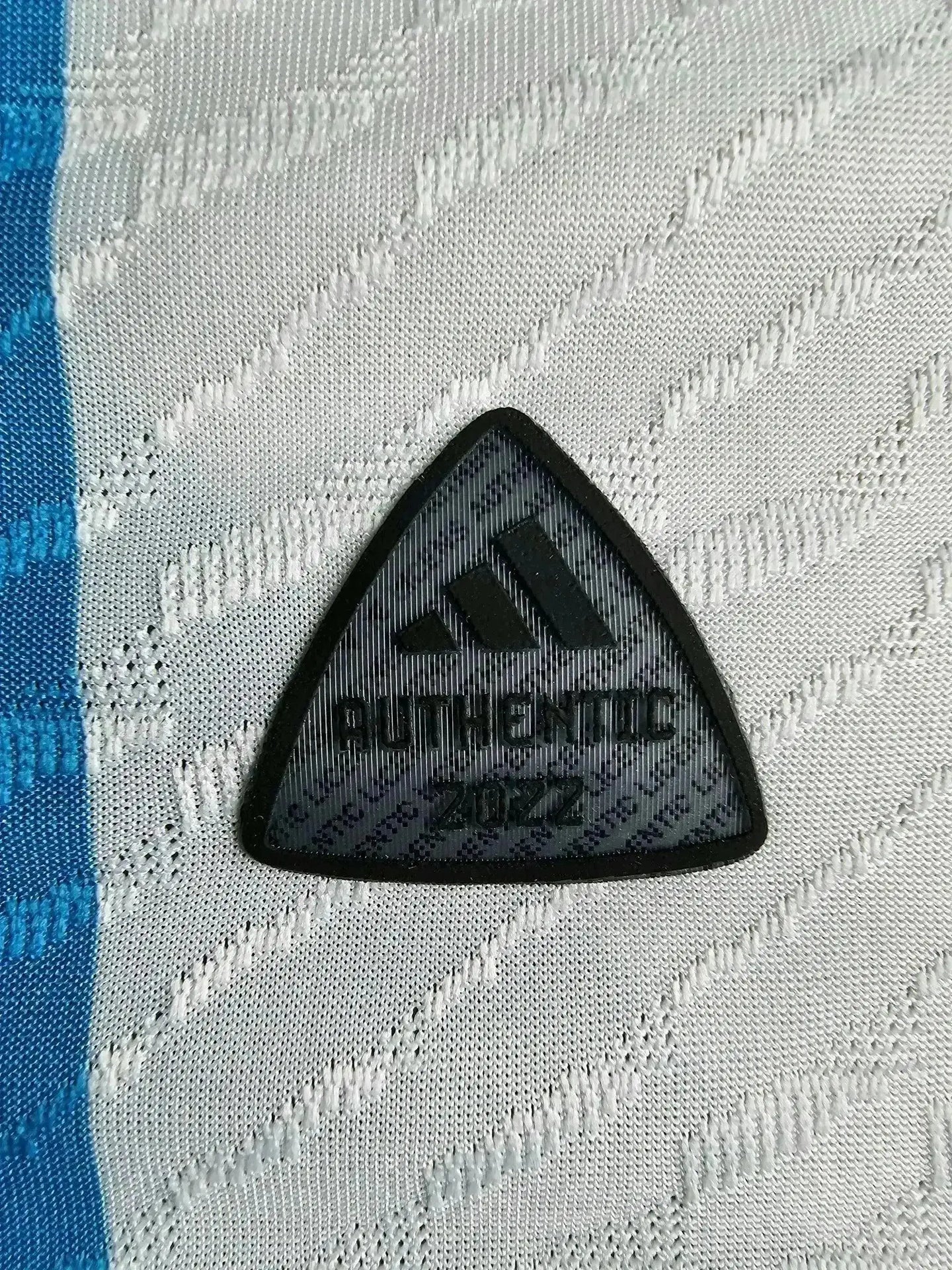Close-up of AUTHENTIC 2022 label on Lionel Messi signed Argentina soccer jersey.
