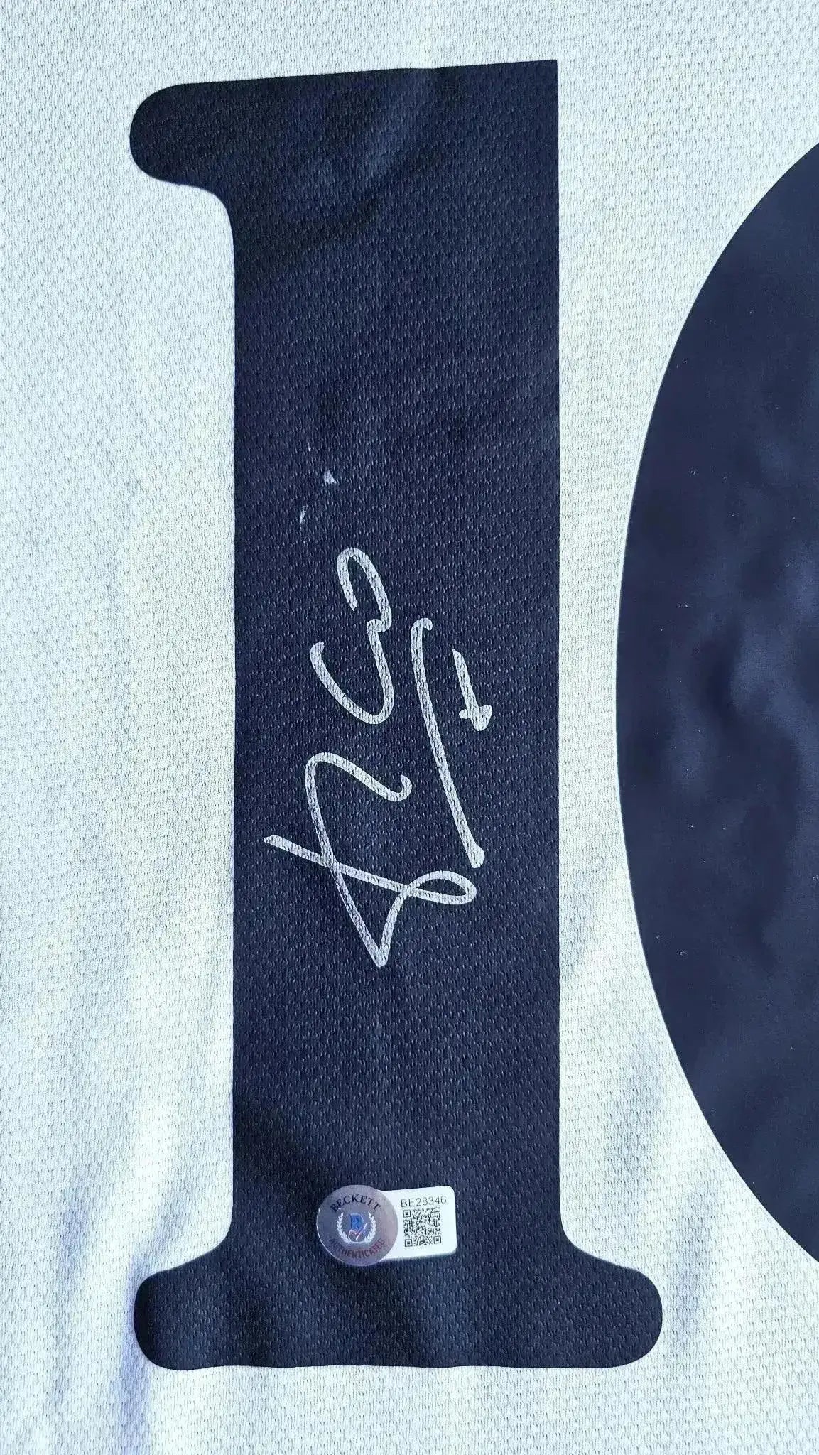 Detail showing the signature of Luis Figo on the No. 10 of the soccer jersey.