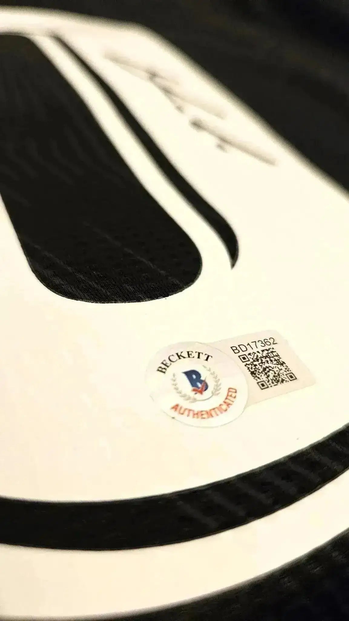 Close-up of Beckett authentication sticker on signed Luka Modrić Real Madrid soccer jersey.