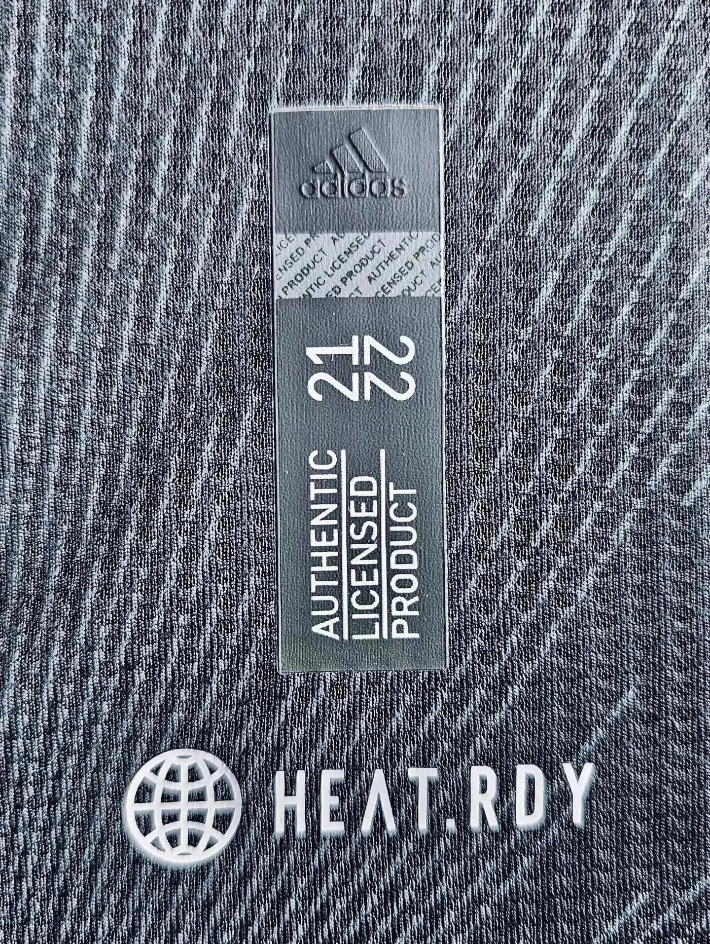 Close-up detail showing adidas logo and authenticity tag with text 'Licensed Product 21 22' and HEAT.RDY.