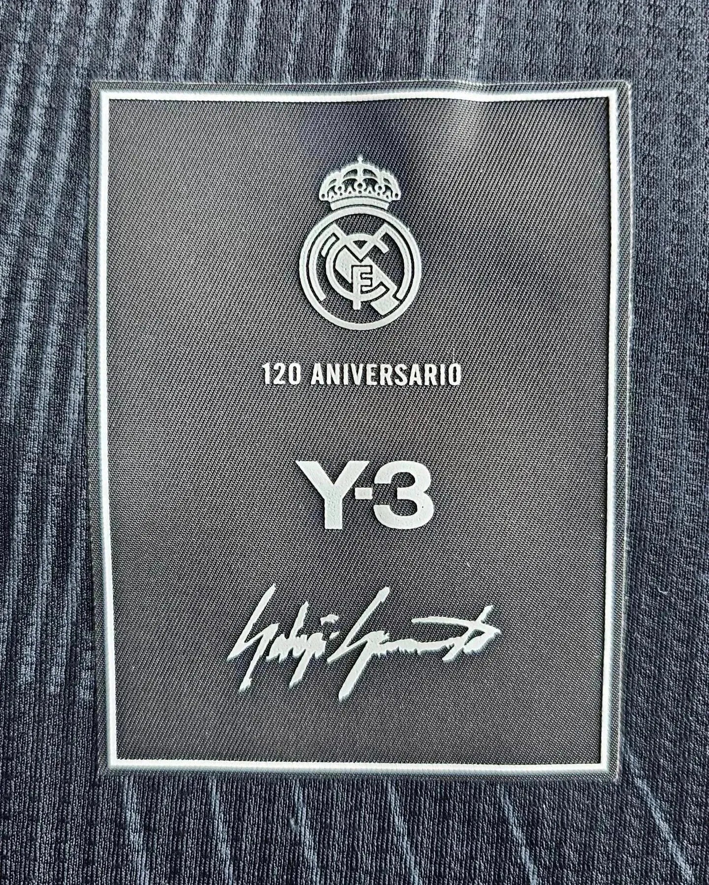 Detail showing Real Madrid crest, 120 Aniversario text, Y-3 logo, and signature at the label.
