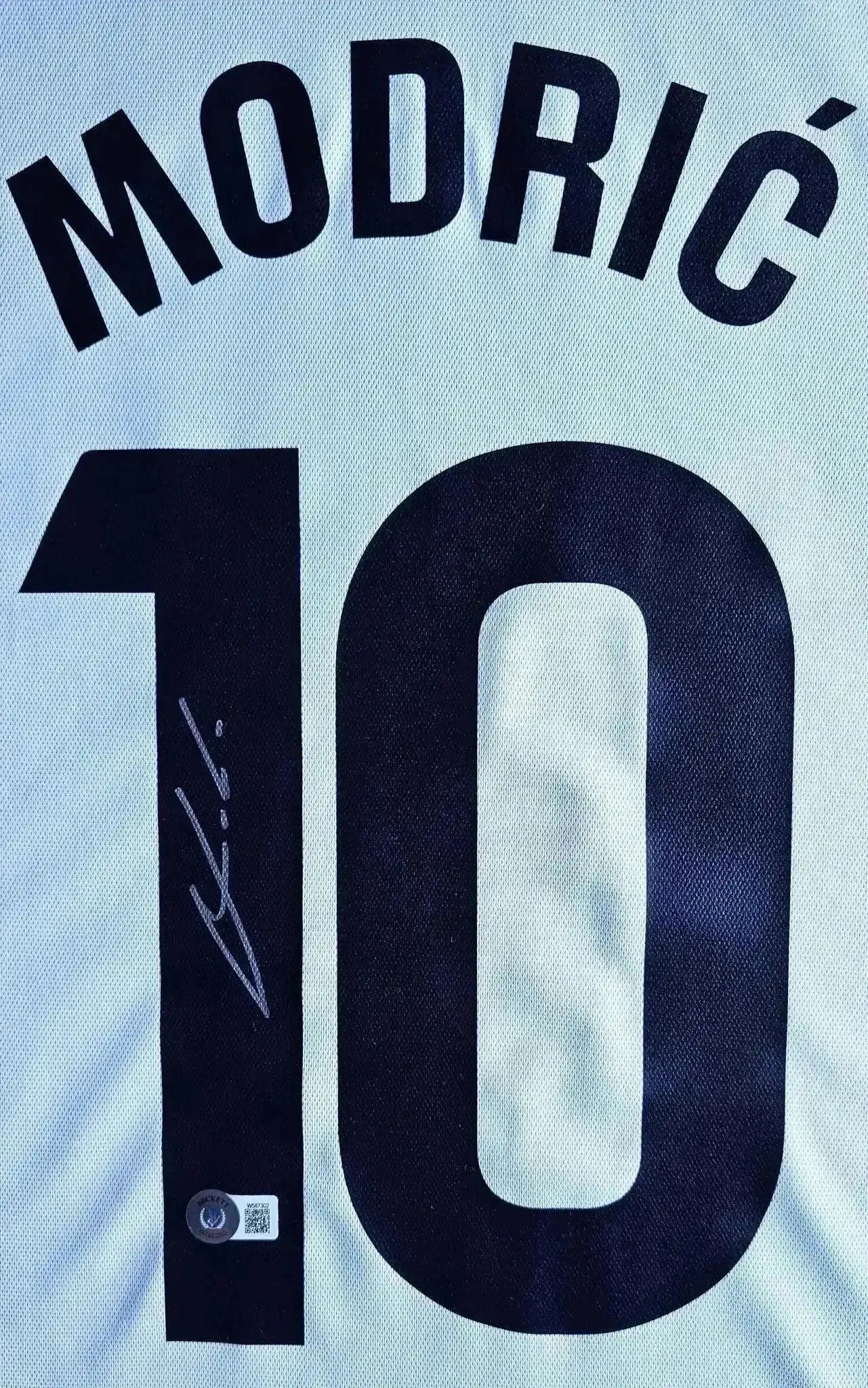 Back view showing No. 10, name MODRIĆ, and signature detail on Real Madrid shirt.