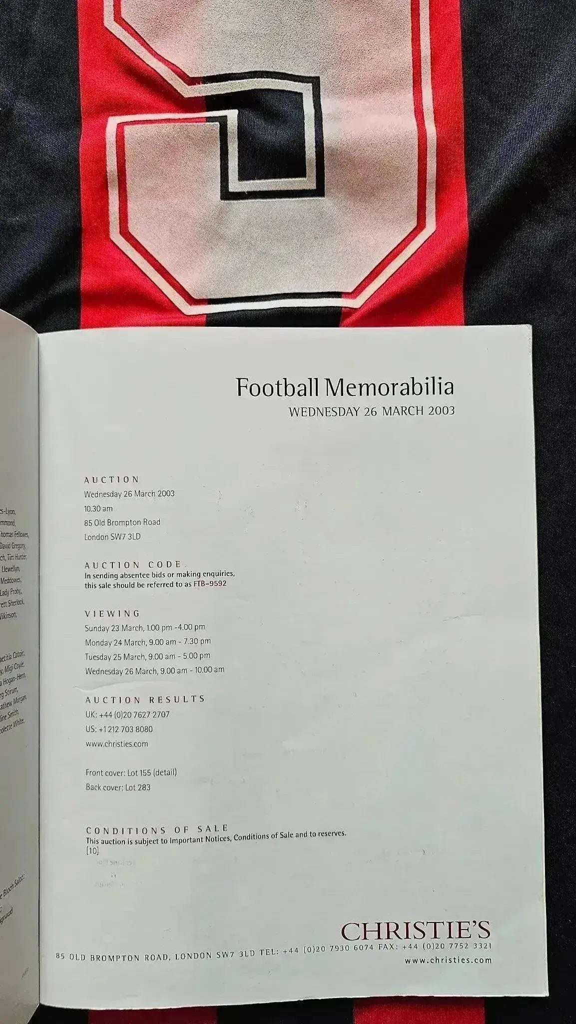 Detail of No. 9 in white with red outline on a striped red and black football shirt.