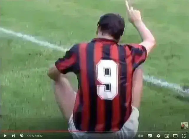 Back view showing No. 9 on a red and black striped AC Milan football shirt.