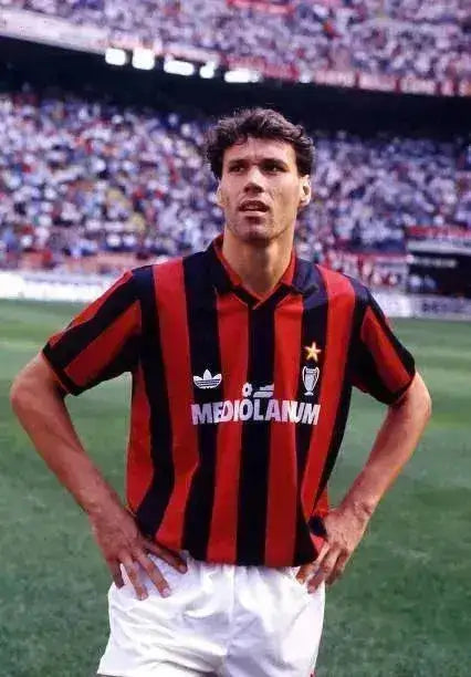 Front view of Marco van Basten wearing a red and black striped AC Milan shirt with a star and sponsor logo.