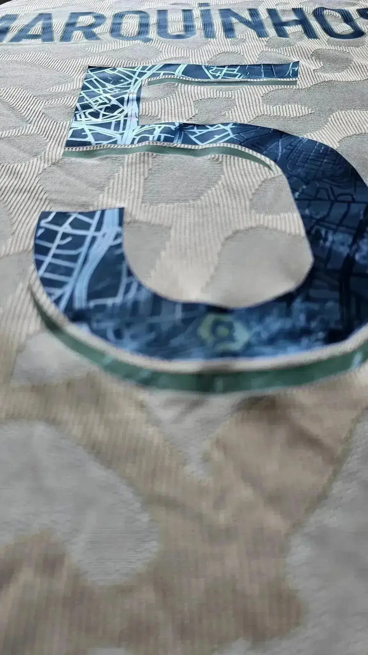 Close-up of the No. 5 and Marquinhos name detail on the signed PSG soccer jersey.
