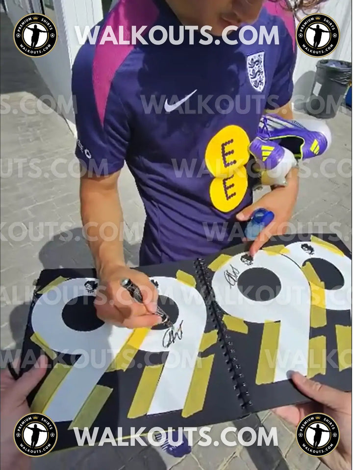 Max Dowman signing a black booklet with visible numbers 9 and 7 along with two signatures.