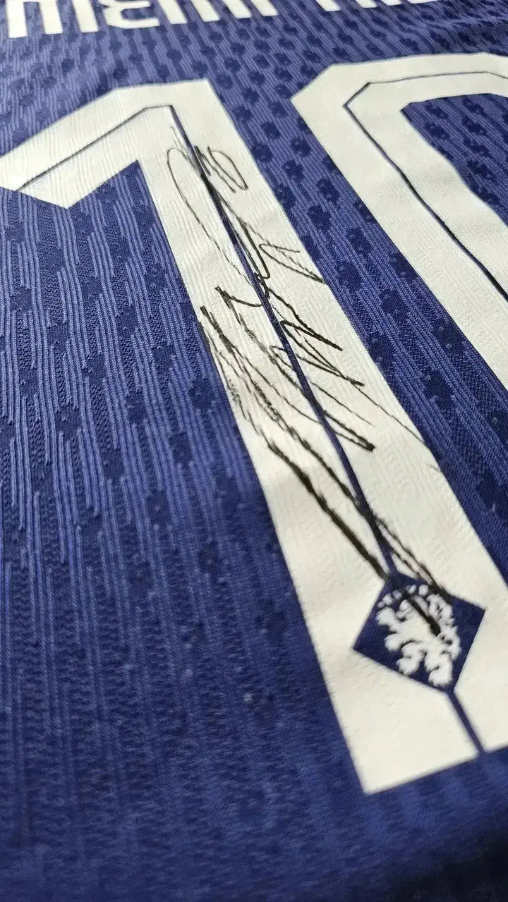 Close-up showing No. 10 and player signature on blue football shirt.