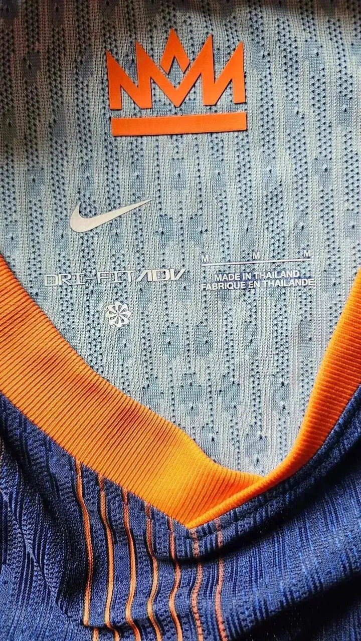 View showing the Nike logo, orange crown emblem, and DRI-FIT ADV details on the collar.