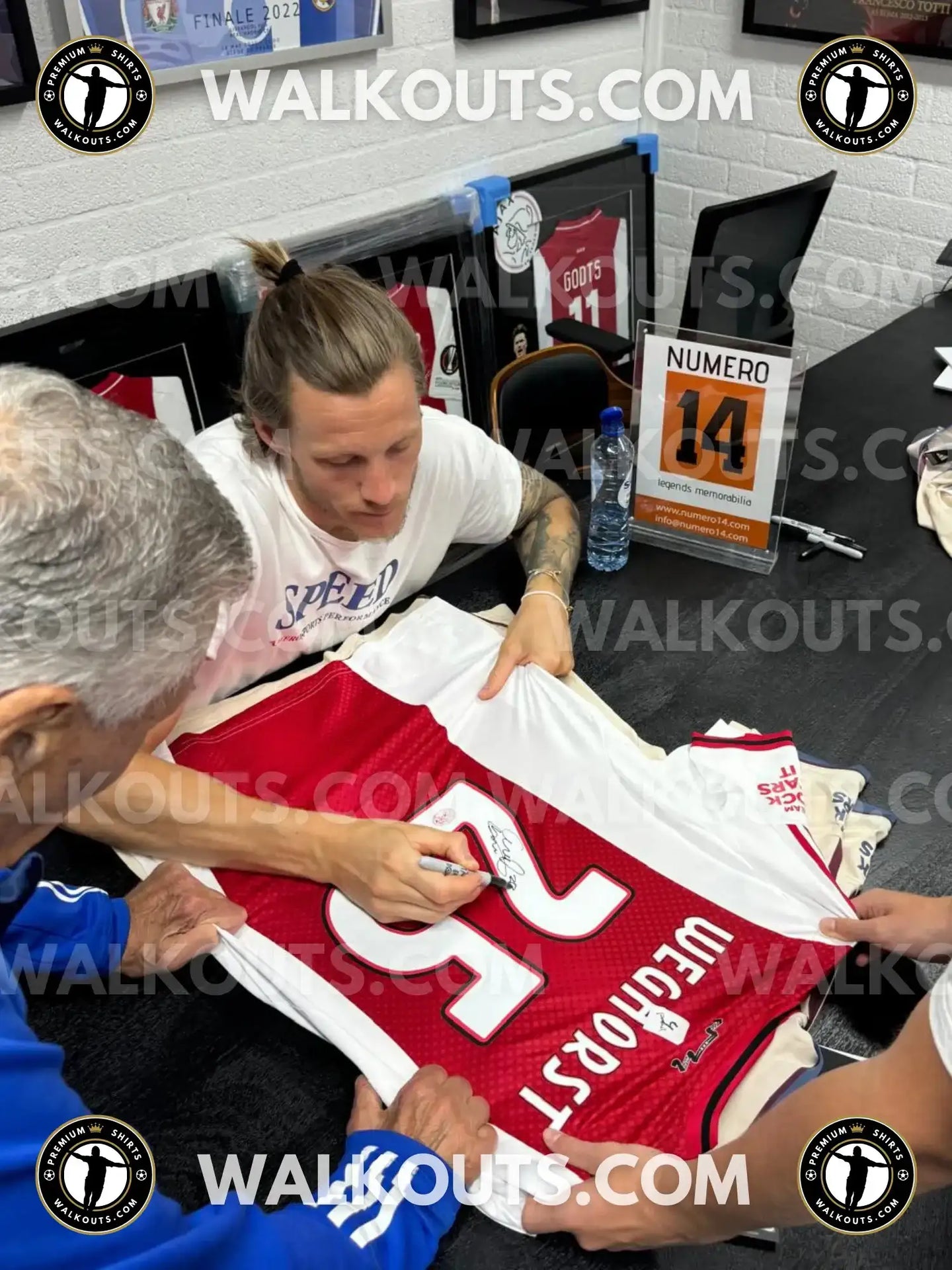 Back view showing No. 25 and signature of Weghorst on a red Ajax soccer jersey.
