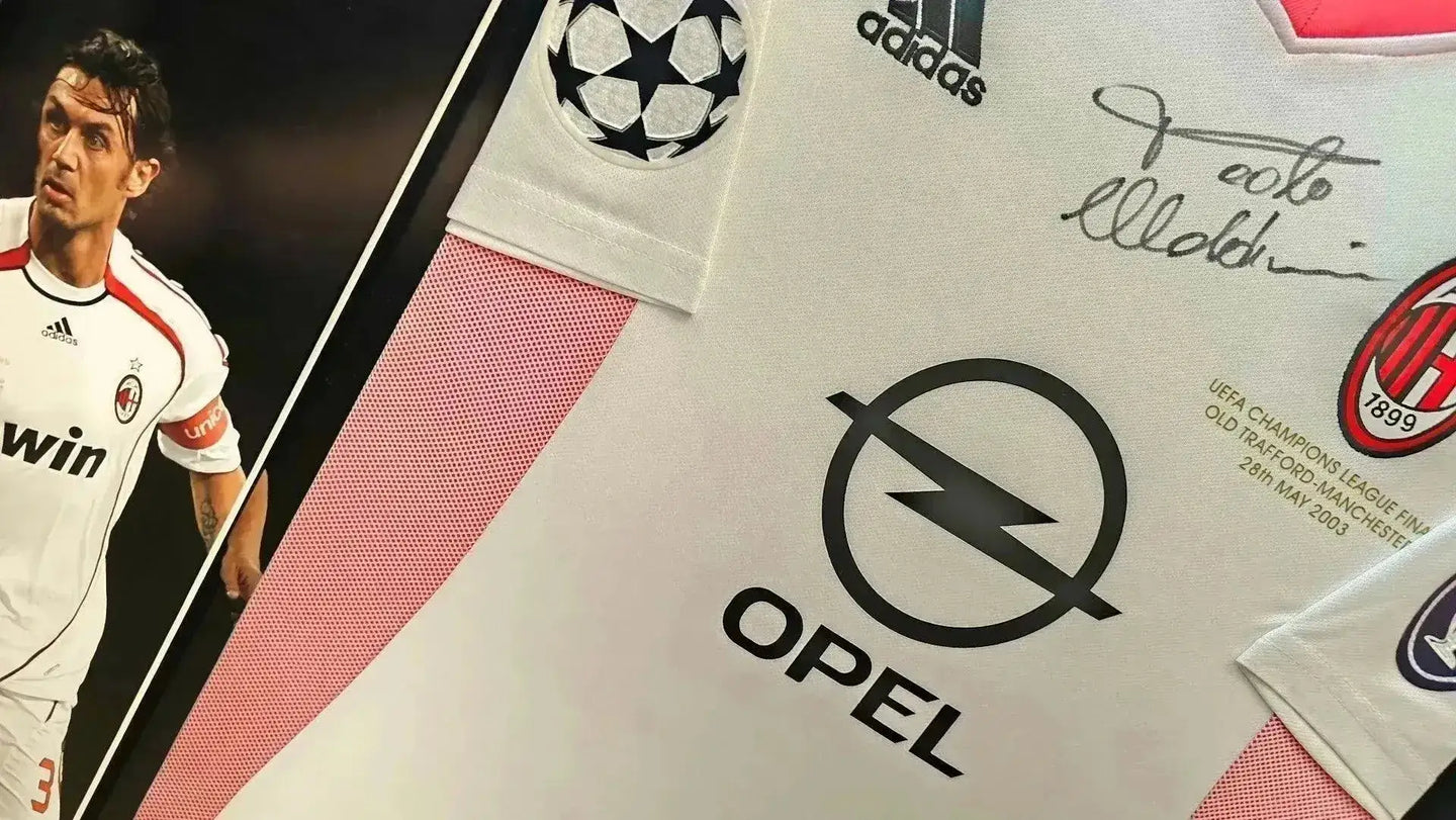 Detail showing signature of Paolo Maldini on AC Milan soccer jersey with UEFA Champions League patch and Opel sponsor.