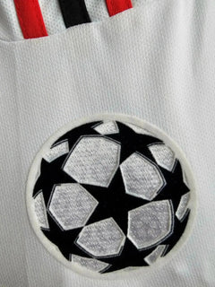 Close-up of UEFA Champions League badge on AC Milan 2002-2003 signed soccer jersey.
