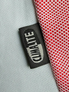 Label detail featuring 'Quality' tag and red mesh fabric on the side of the soccer jersey.