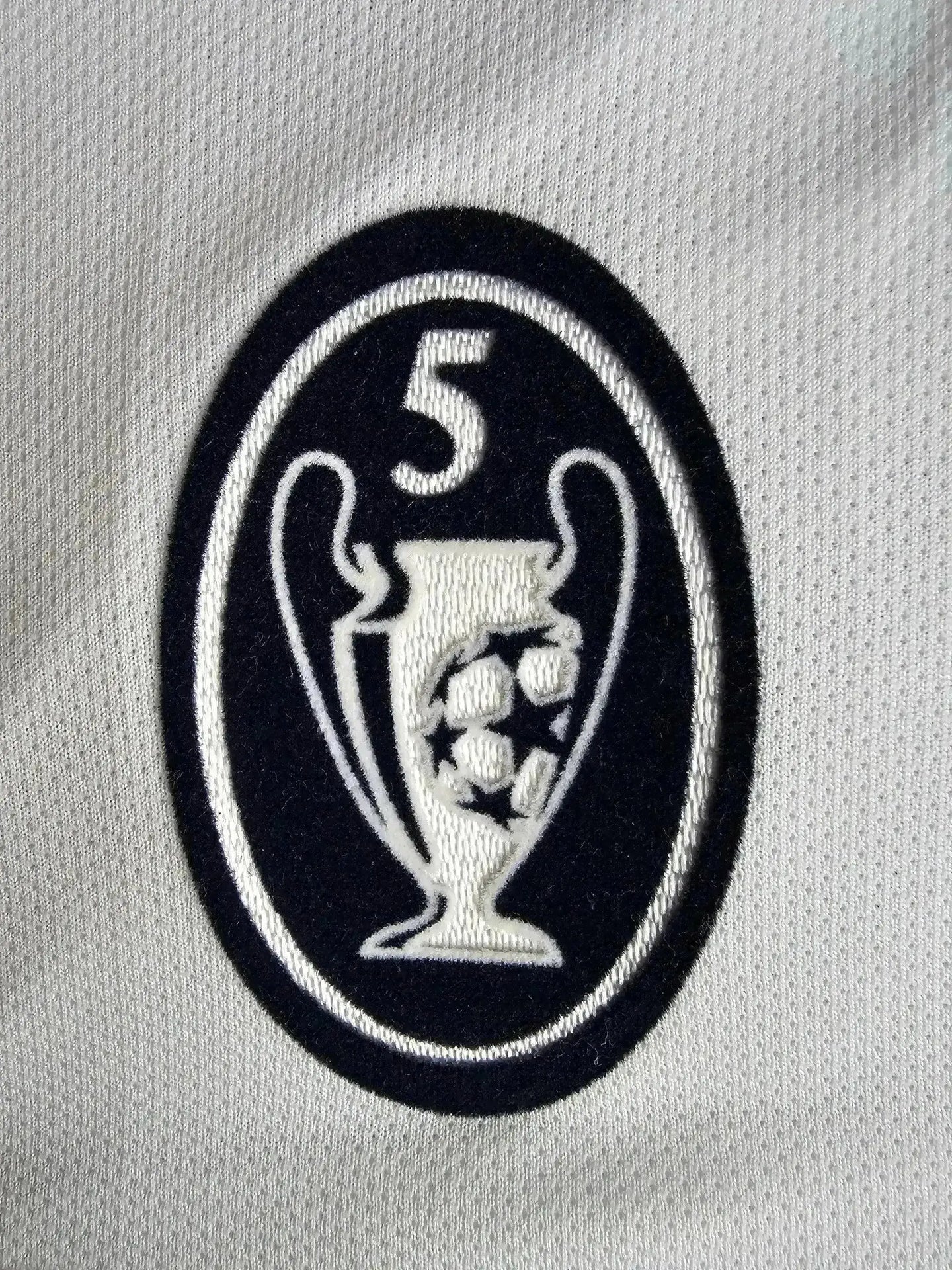 Detail of UEFA Champions League trophy crest with five stars and footballs.