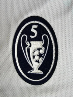 Detail of UEFA Champions League trophy crest with five stars and footballs.