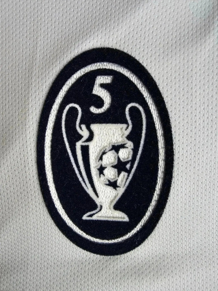 Detail of UEFA Champions League trophy crest with five stars and footballs.