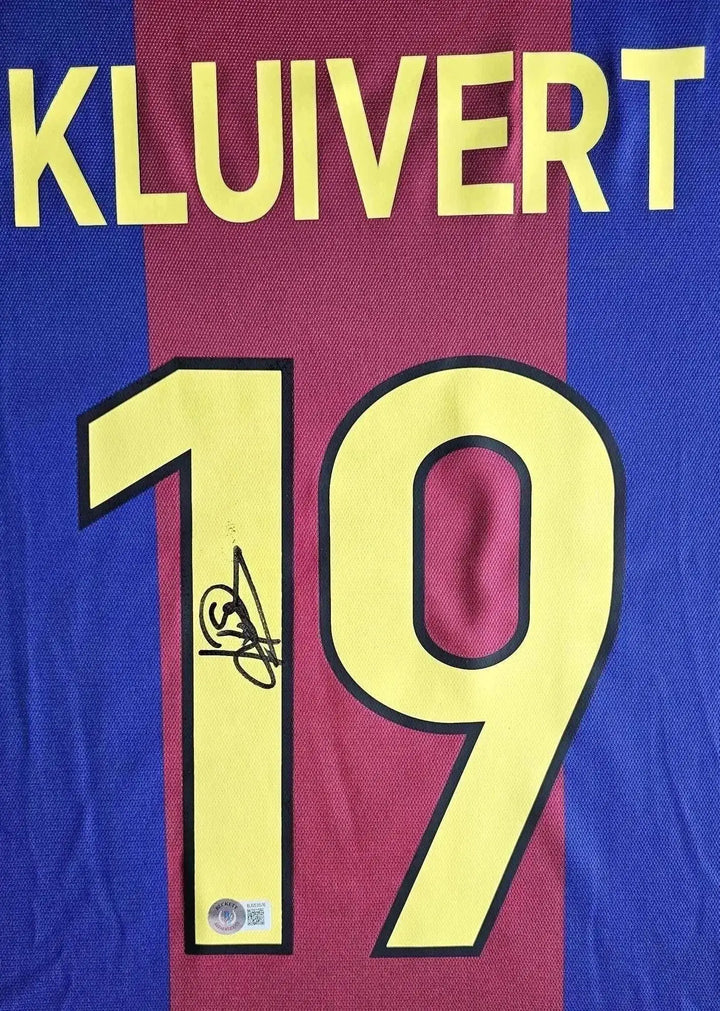 Front view showing Kluivert, No. 19 and a visible signature on the Barcelona football shirt.