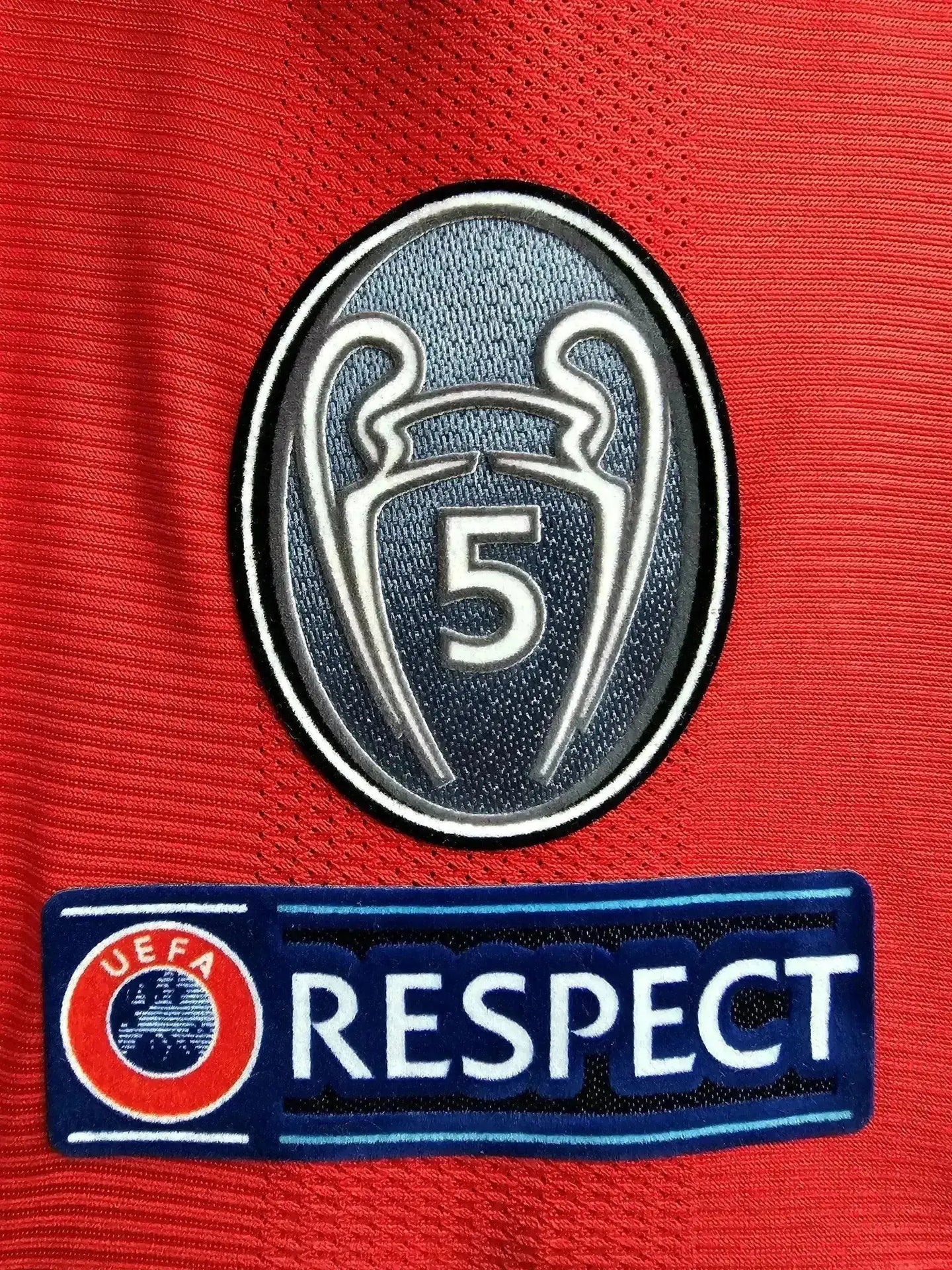 Crest detail featuring the UEFA Champions League logo with five stars and UEFA Respect badge.