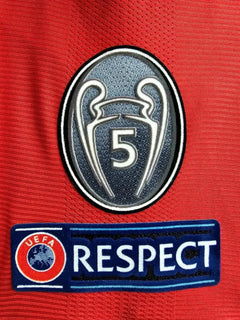 Crest detail featuring the UEFA Champions League logo with five stars and UEFA Respect badge.