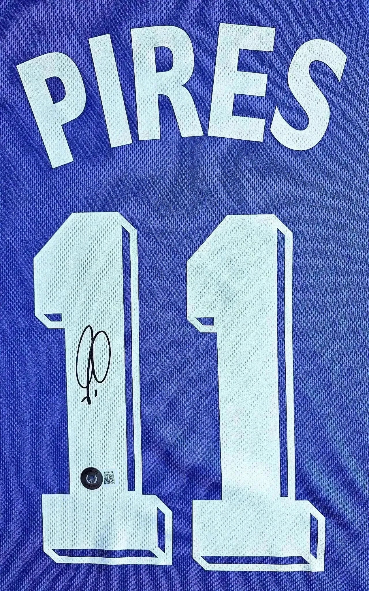 Back view showing No. 11, PIRÈS, and signature detail on the soccer jersey.