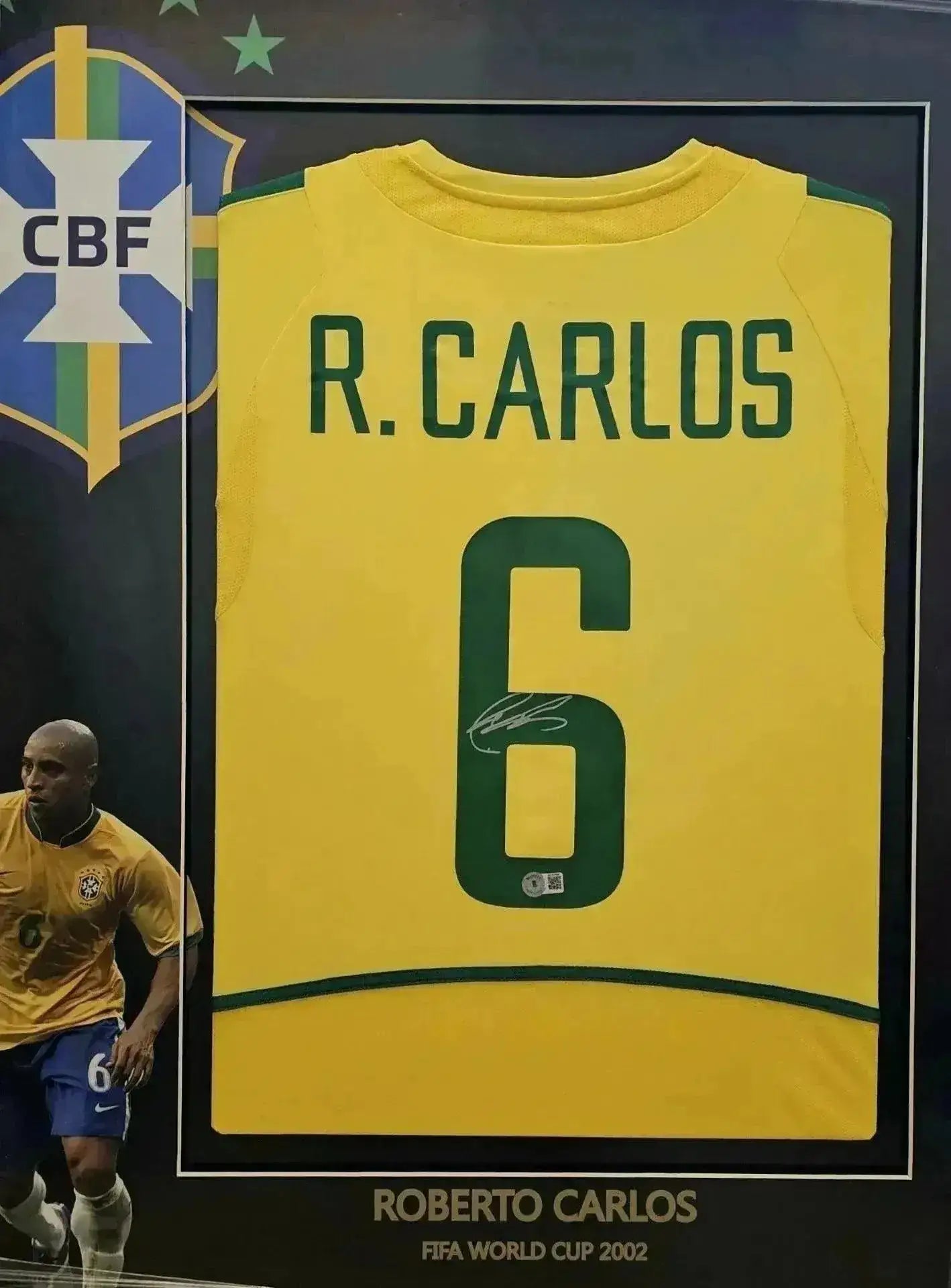Back view showing R. CARLOS, No. 6, and signature on a Brazil soccer jersey framed with a crest.