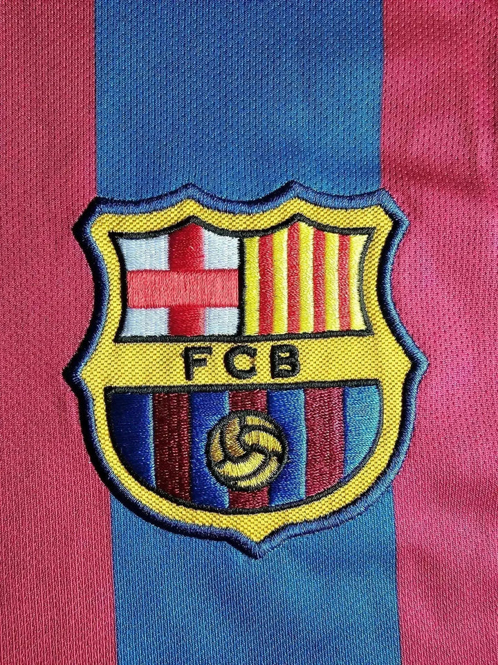 FC Barcelona crest detail featuring red and blue stripes with the shield and FCB text.