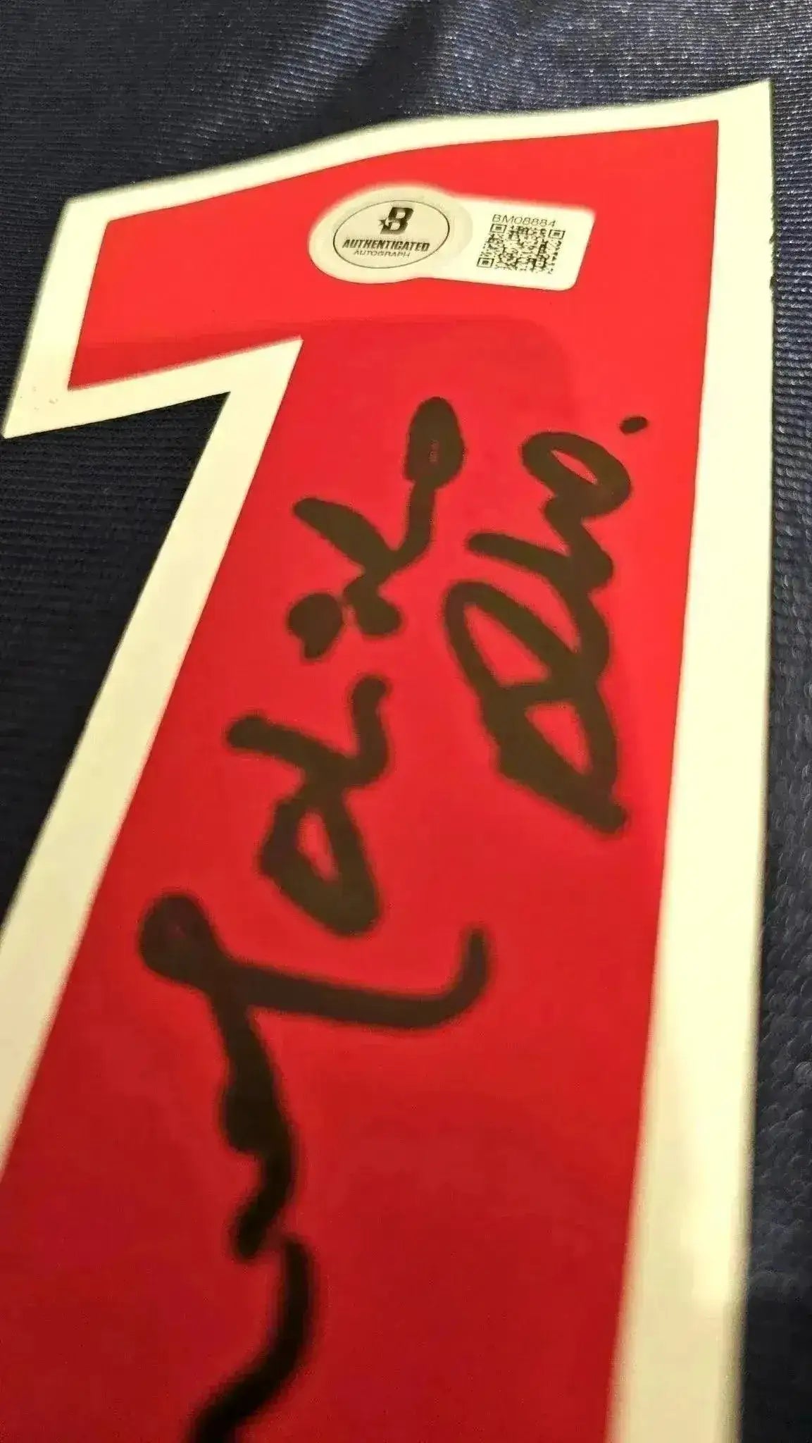 Detail showing signature of Ronaldinho on the red No. 10 patch with authentication sticker.