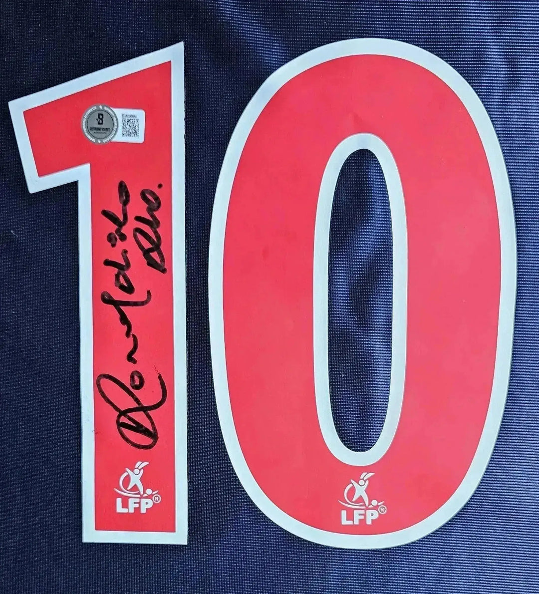 Number 10 in red with Ronaldinho's signature below on a blue background.