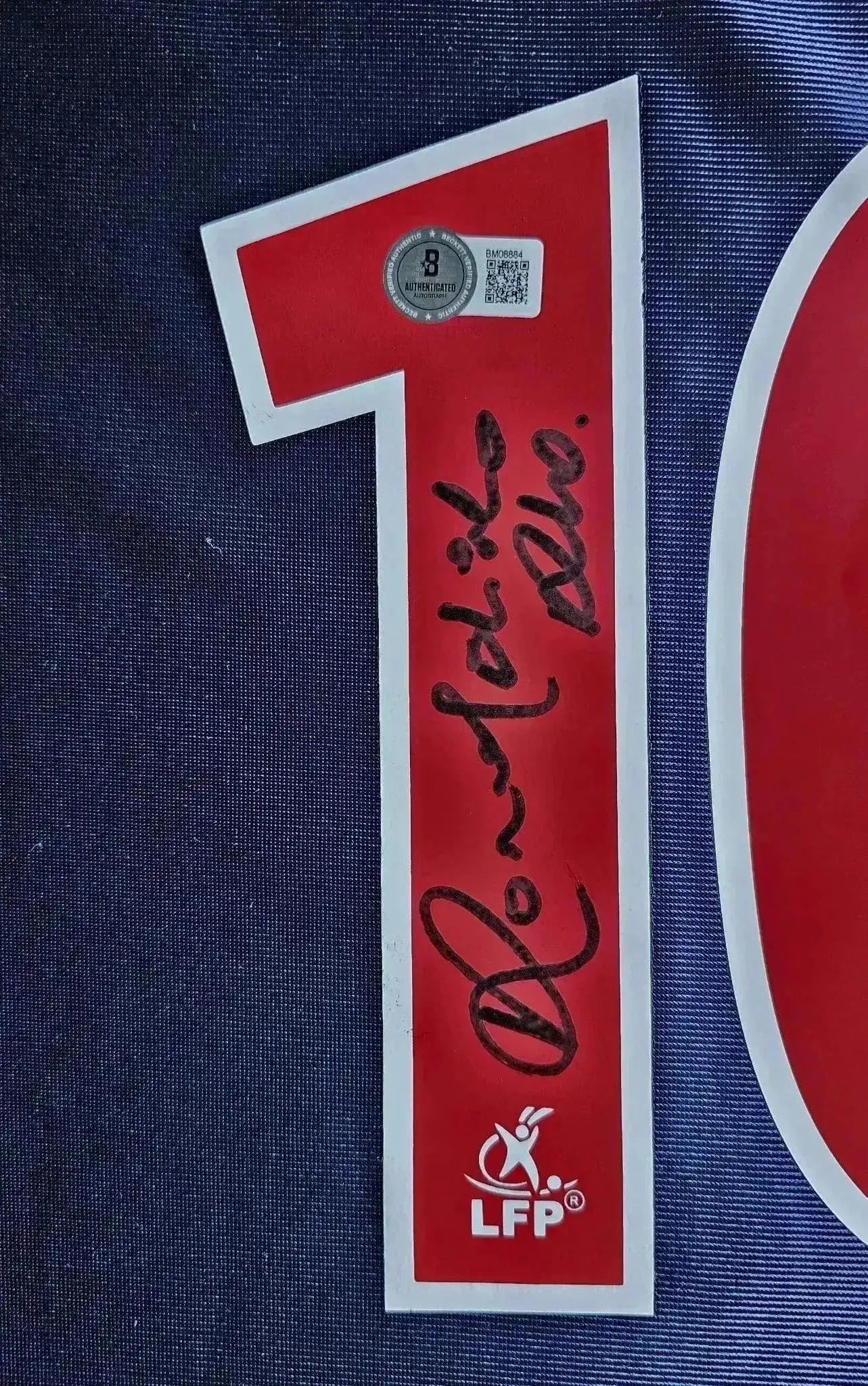 Red No. 10 with Ronaldinho's signature and an authentication sticker on blue fabric.