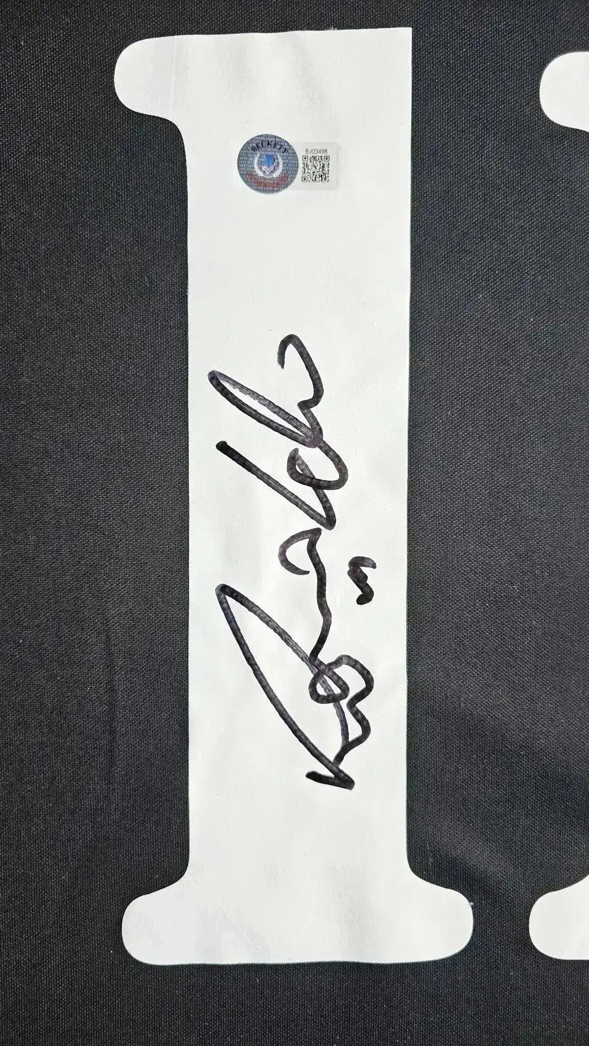 Signature of Ronaldo Nazário on the white label of a Real Madrid soccer jersey.