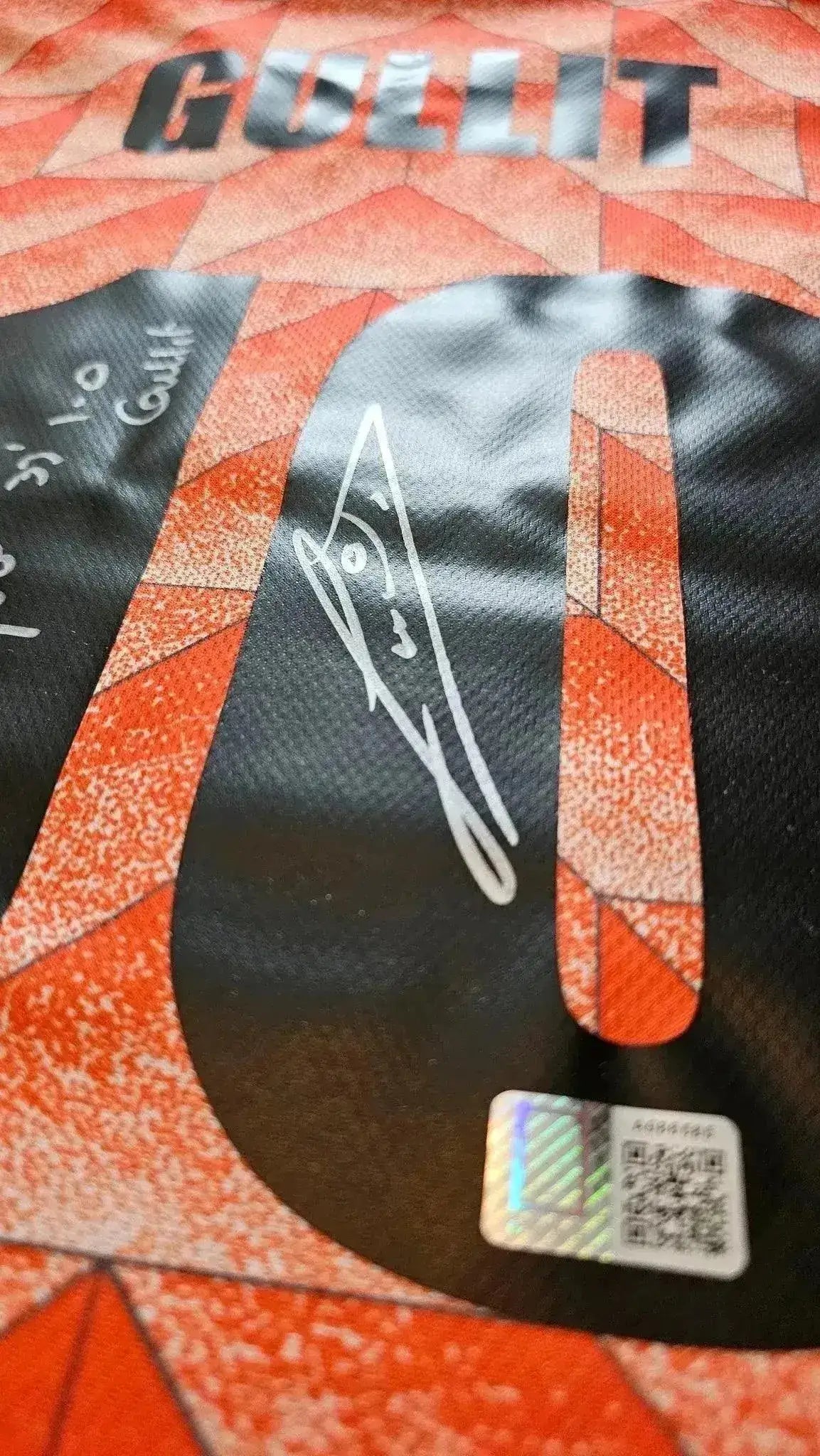 Detail view showing the No. 10 and Ruud Gullit's signature on the soccer jersey.