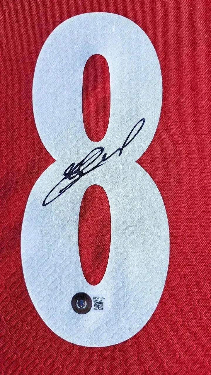 Close-up of No. 8 with signature on red Liverpool football shirt.