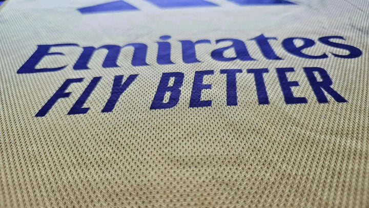 Close-up of the Emirates Fly Better sponsor logo on the signed football shirt.