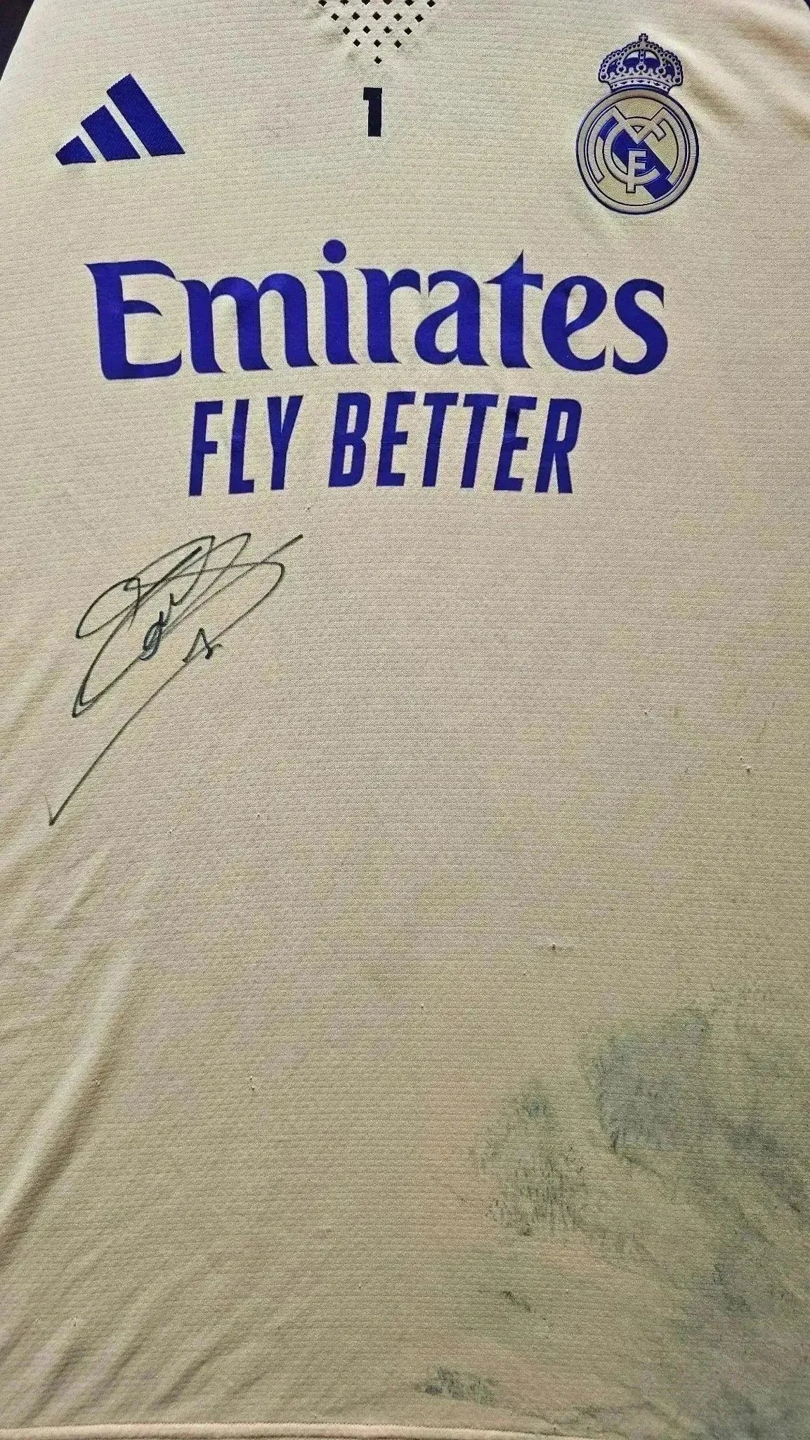 Front view featuring No. 1 and signature on a Real Madrid shirt with 'Emirates Fly Better' text.