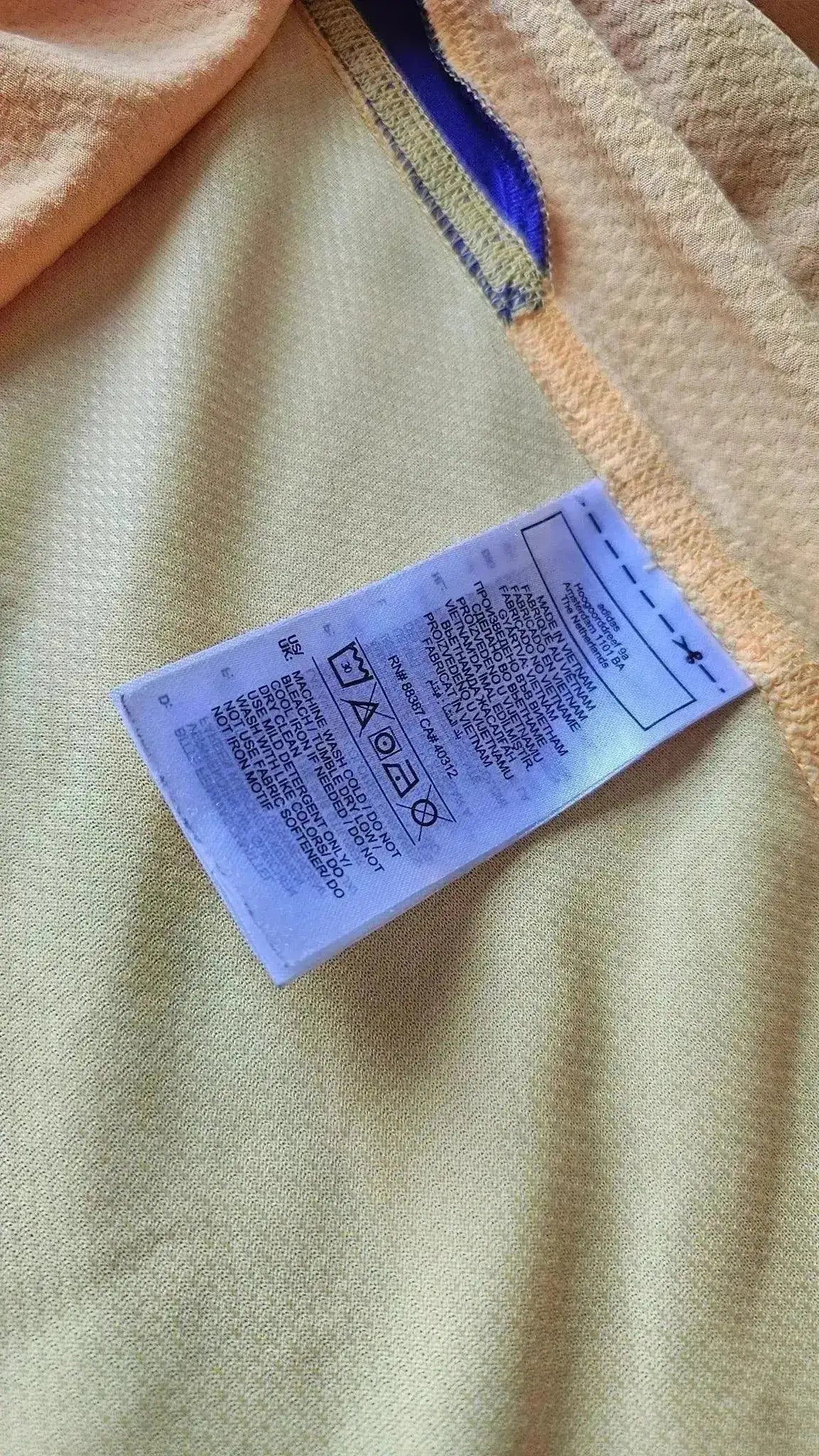 Care label showing washing instructions for signed Thibaut Courtois 1 Real Madrid shirt.