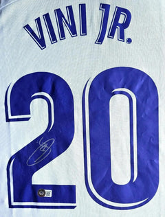 Detail of signed shirt showing the name 'VINI JR.' and number '20' with a visible signature.