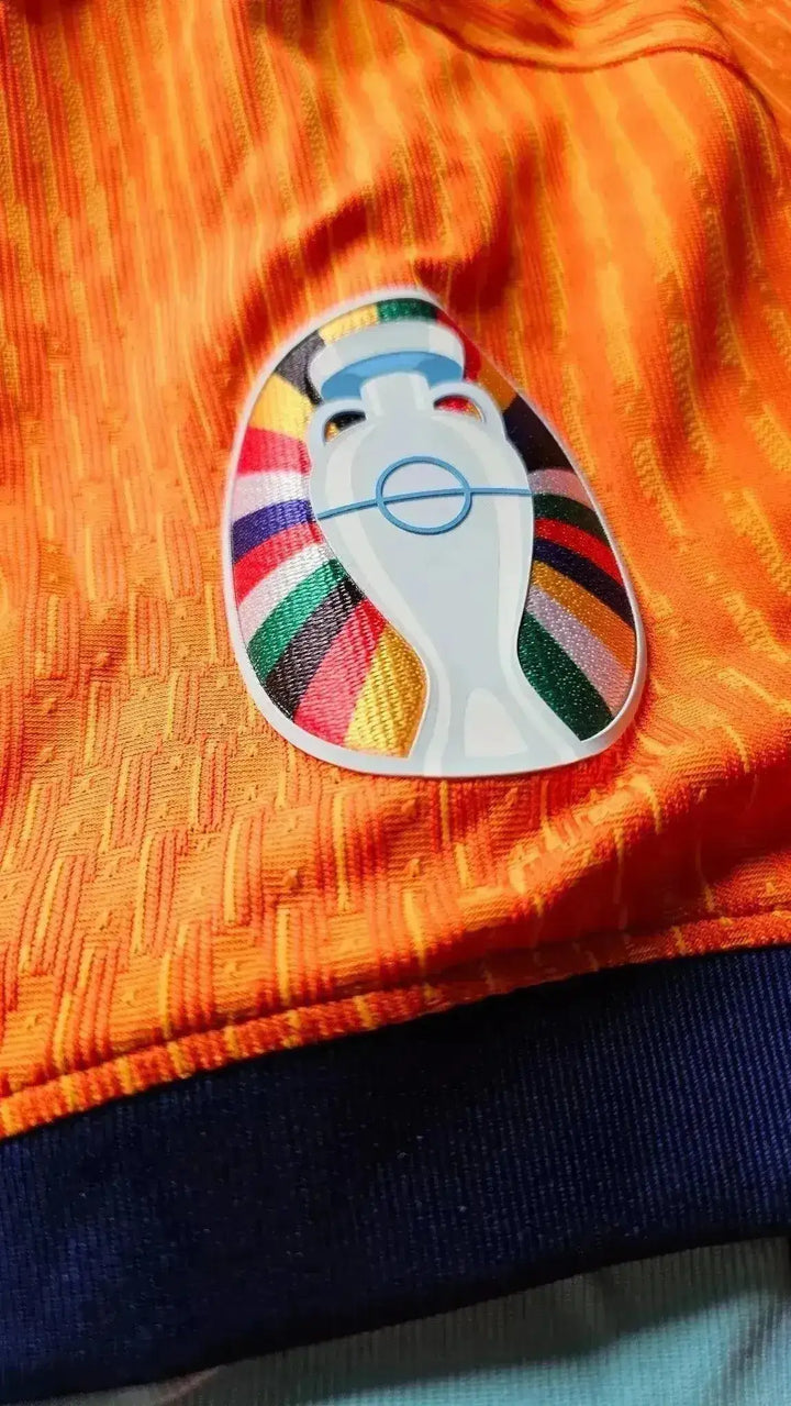 Crest detail featuring the colorful UEFA Euro logo on an orange football shirt.