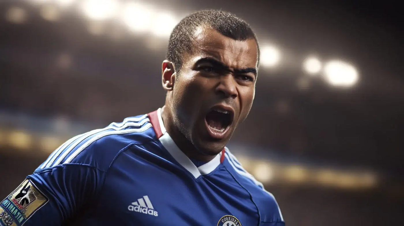 Ashley Cole shouting in a blue Chelsea football shirt with white shoulder stripes and red collar trim, stadium lights out of focus behind him.