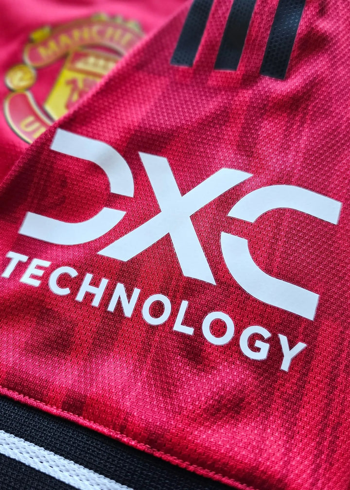 Close-up of the Manchester United crest edge and DXC Technology sponsor print on the sleeve, Bendito Mantato's No. 70 shirt, 2025-2026.