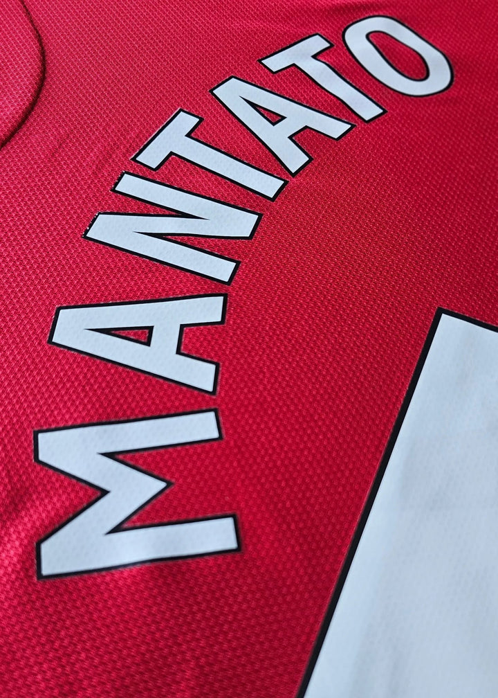 Angled close-up of the white MANTATO lettering on Bendito Mantato's red Manchester United F.C. shirt, No. 70, 2025-2026.