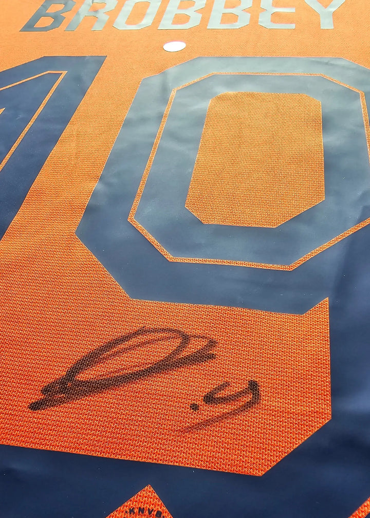 A black-ink signature written across the navy number on the back of Brian Brobbey's orange Netherlands shirt, from his signed Euro 2024 shirt.