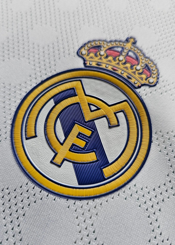 Close-up detail of the Real Madrid crest featuring a gold crown and the initials R, M, and C.