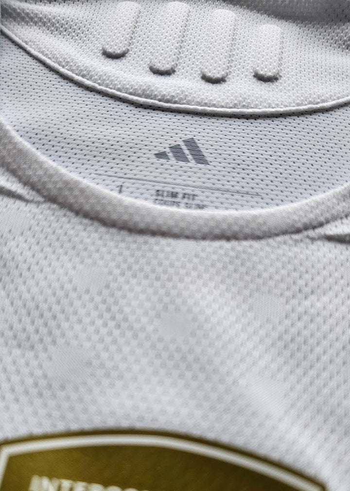 Close-up of the collar and care label showing adidas logo and slim fit details on the football shirt.