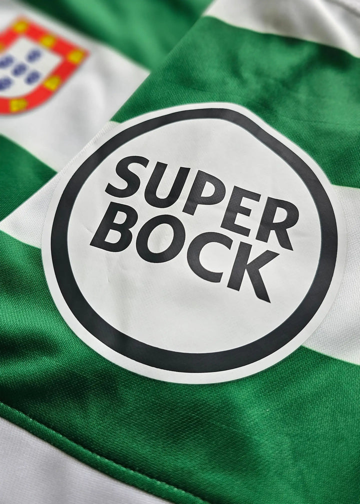 Close-up of a green and white striped soccer jersey with a circular 'SUPER BOCK' sponsor logo on the chest.