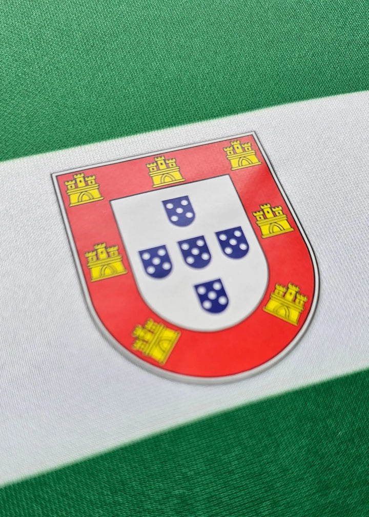 Detail of a shield patch bearing Portugal's historic castles and quinas design on the shirt sleeve.